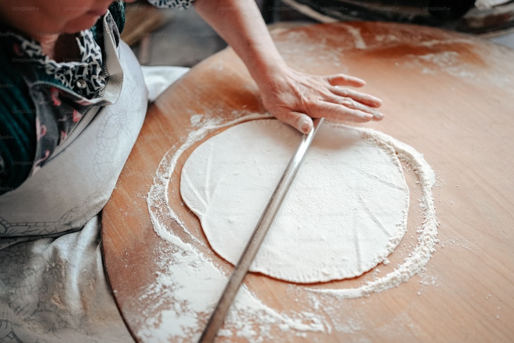 a woman is making a dough on a table