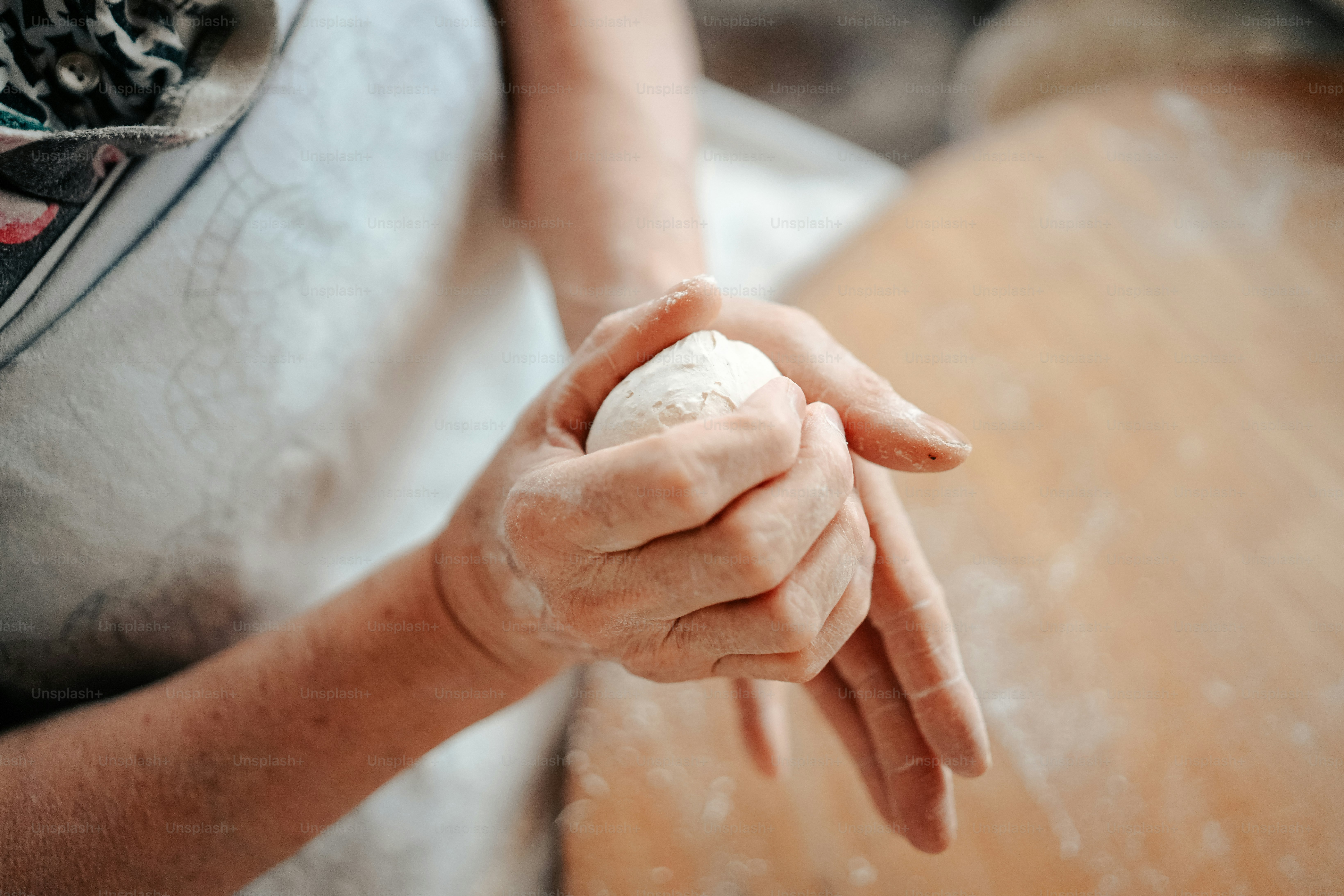 a woman holding a ball of dough in her hands