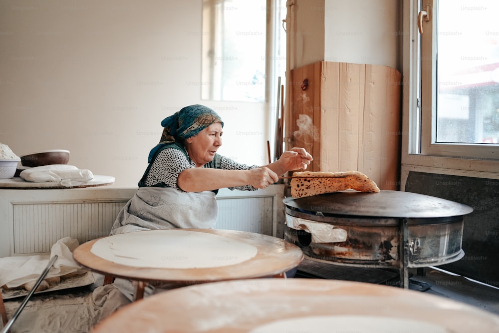 uma mulher está fazendo um sanduíche em uma cozinha