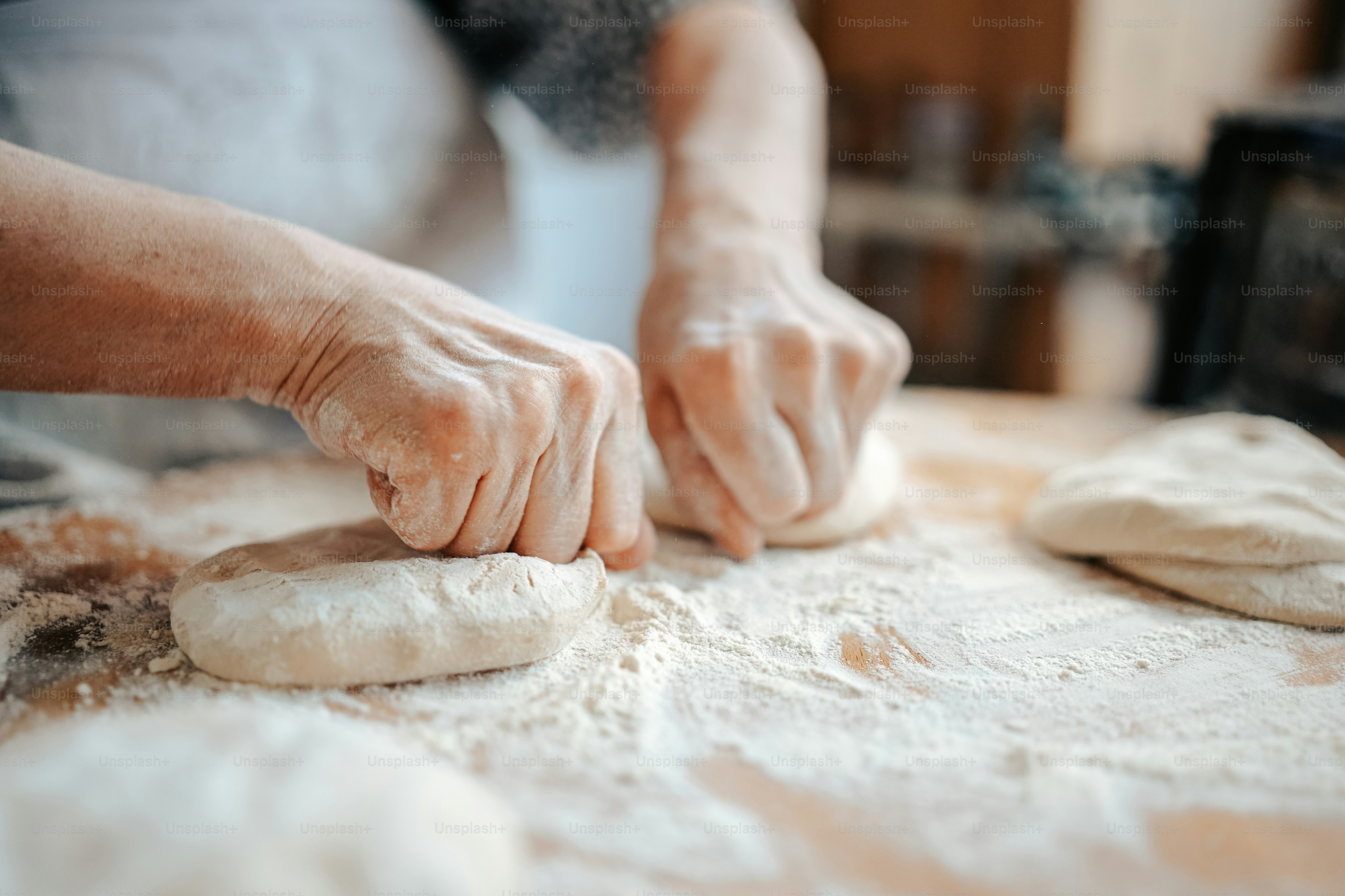 a person kneading dough on top of a table