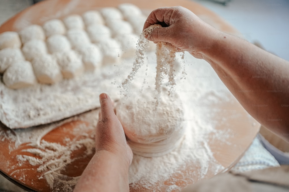 Una persona está rociando harina sobre una mesa