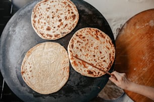 three flat breads are being cooked on a skillet