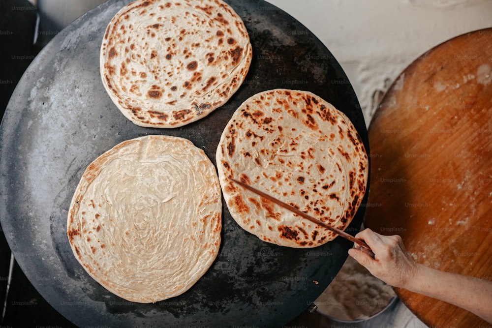 three flat breads are being cooked on a skillet