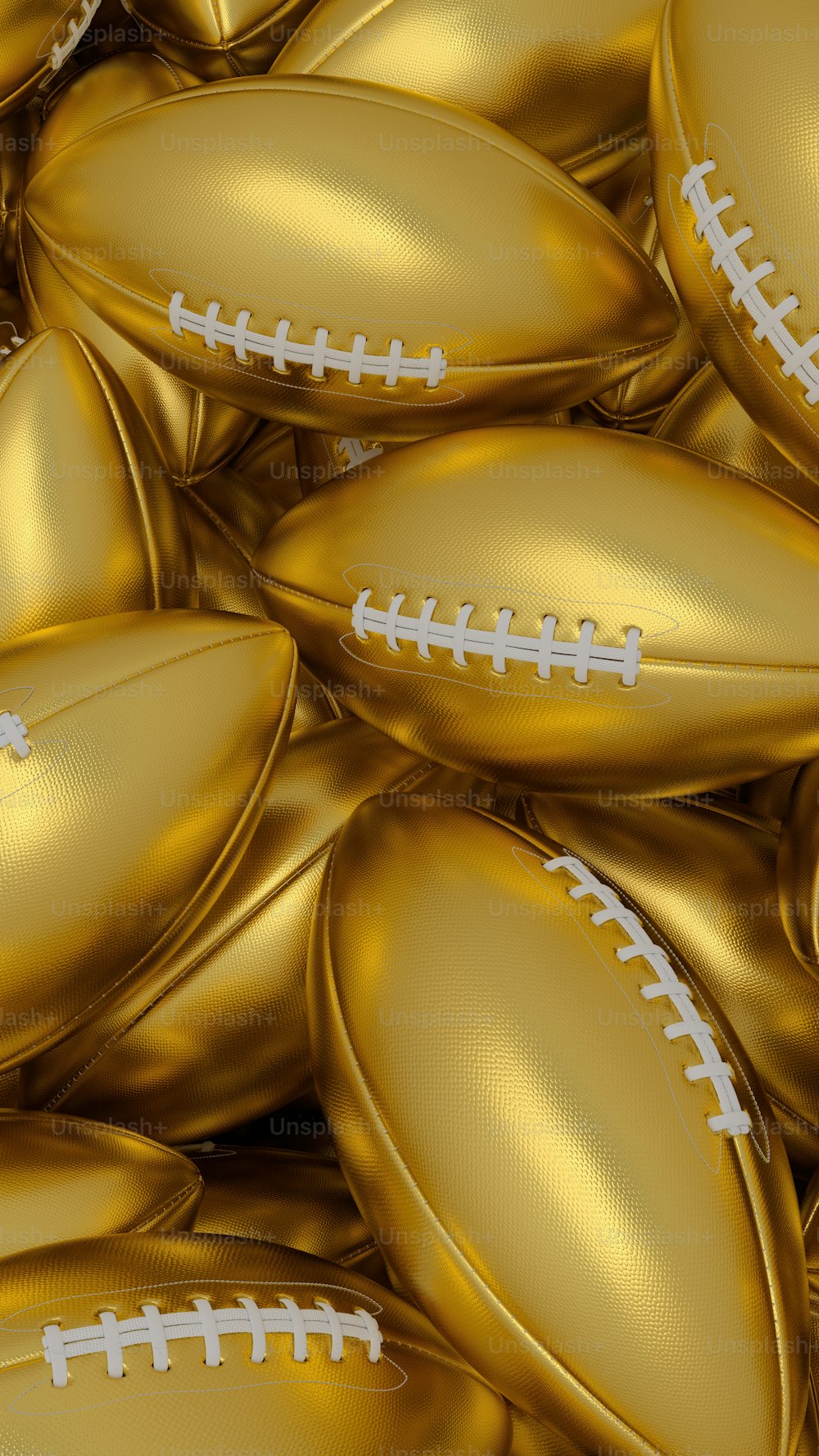 a pile of gold footballs with white stitching
