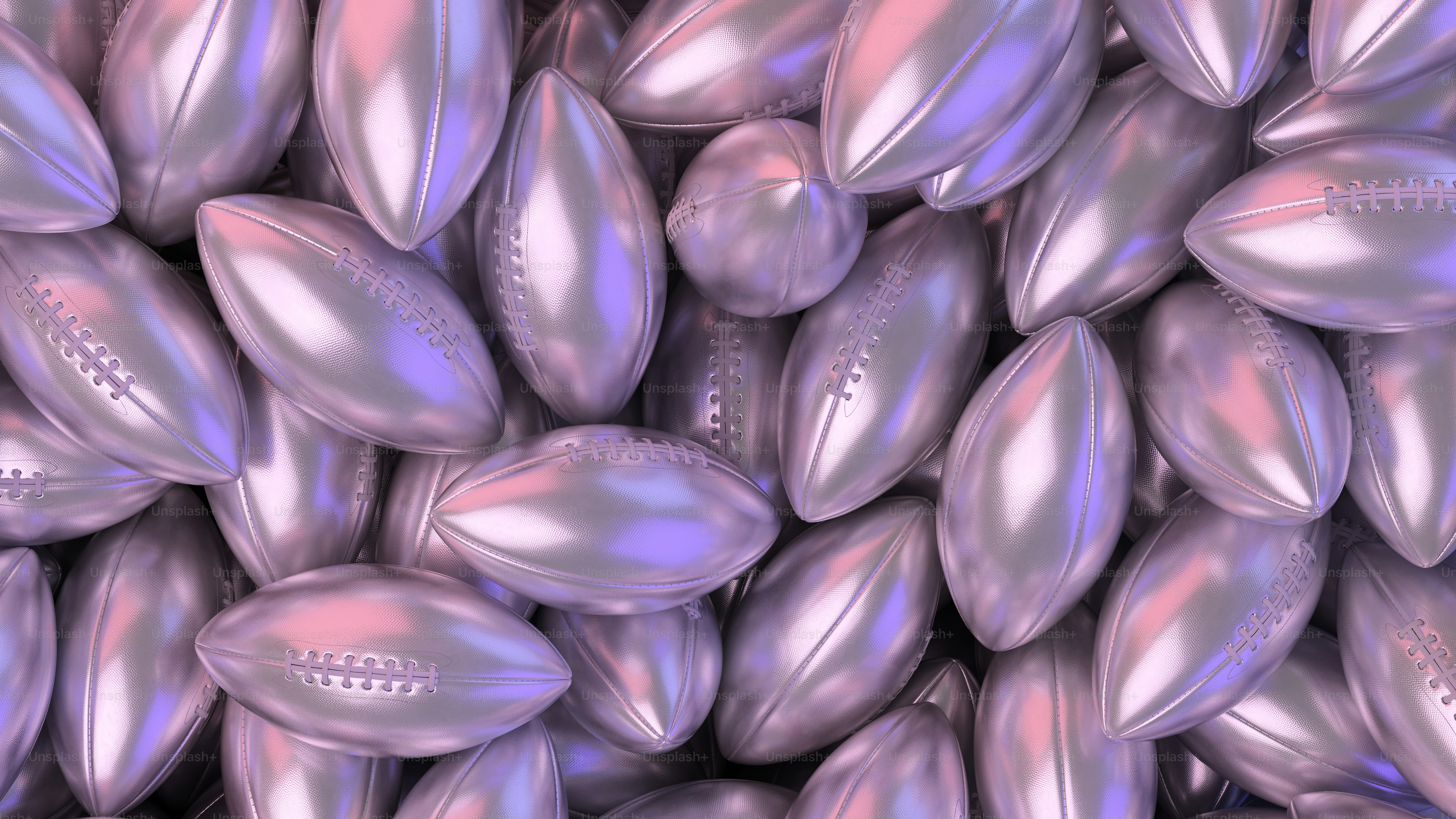 a pile of shiny silver footballs sitting on top of each other