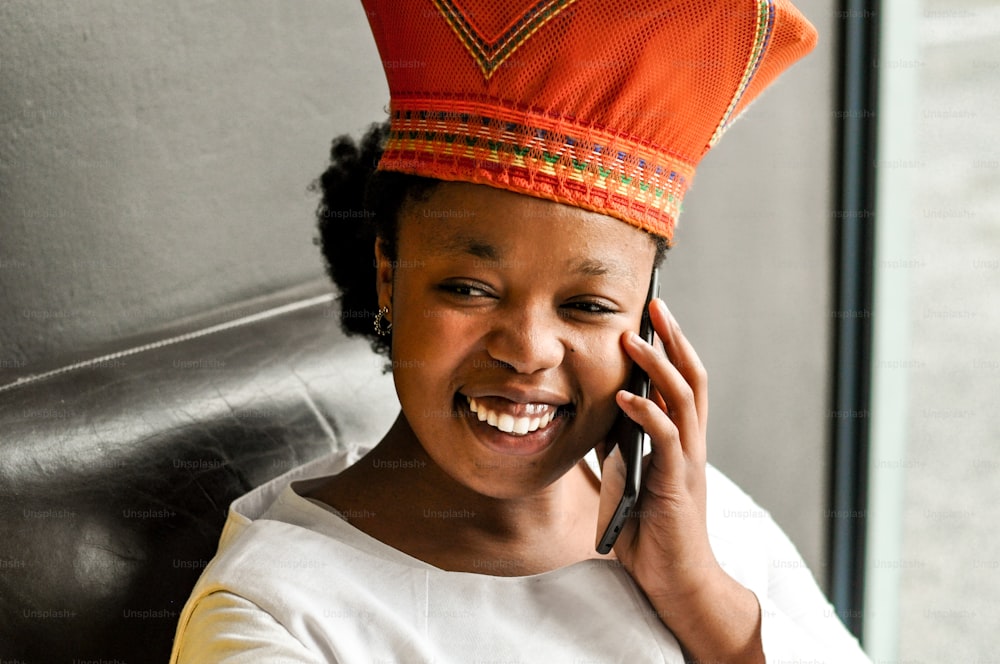 uma mulher em um chapéu vermelho falando em um telefone celular