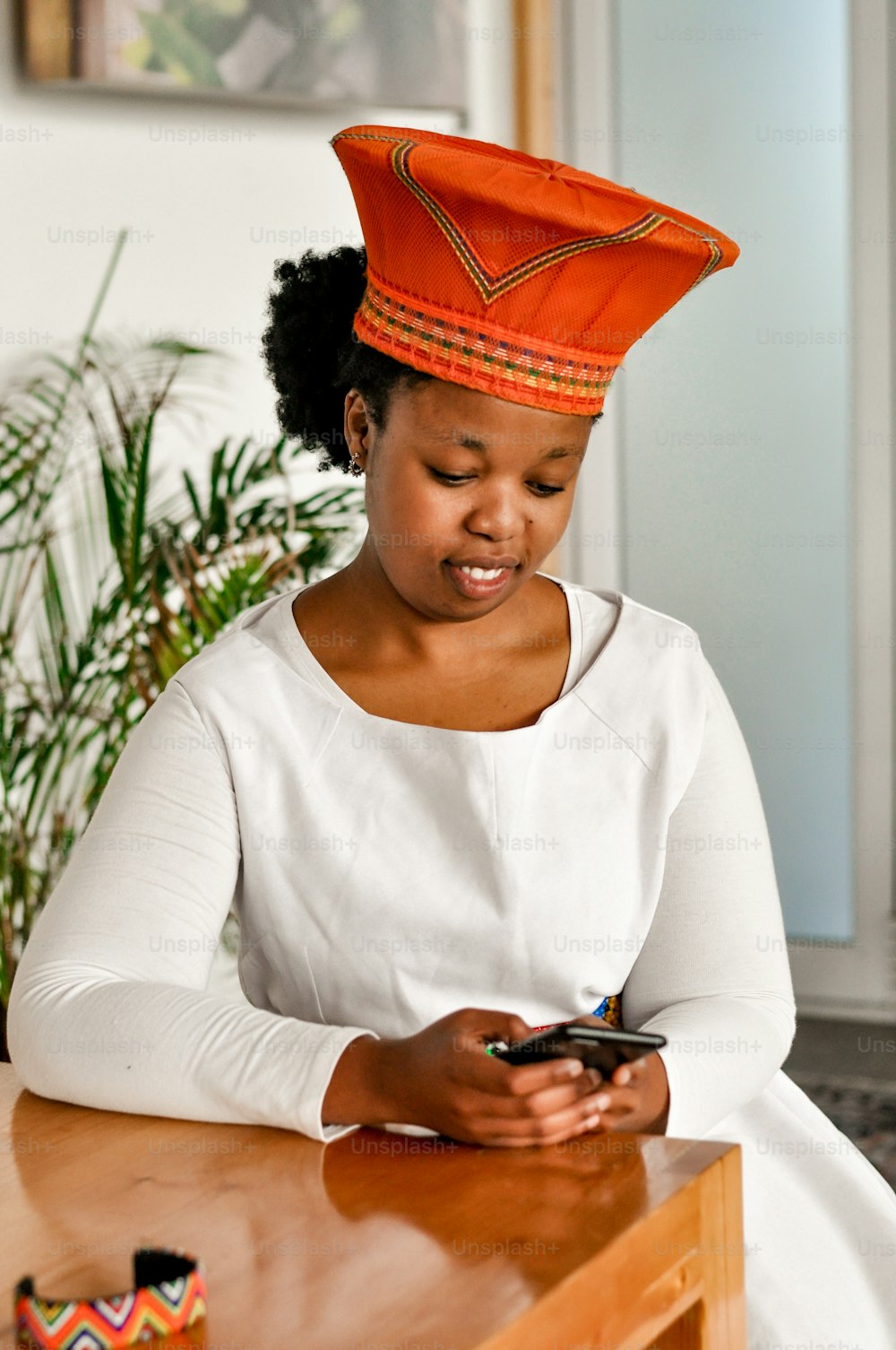 Eine Frau sitzt an einem Tisch und schaut auf ihr Handy
