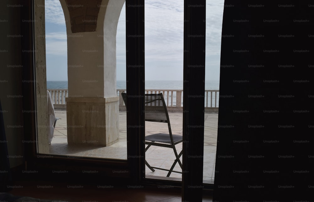 a balcony with a chair and a view of the ocean