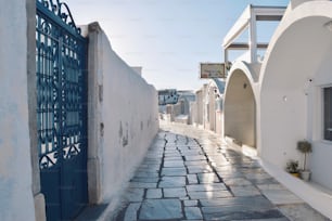 a cobblestone street lined with white buildings