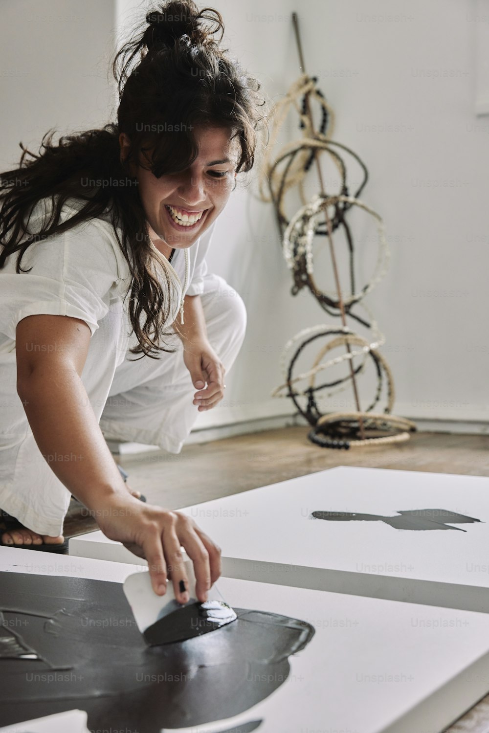 한 여성이 예술 작품을 작업하는 동안 �웃고 있다
