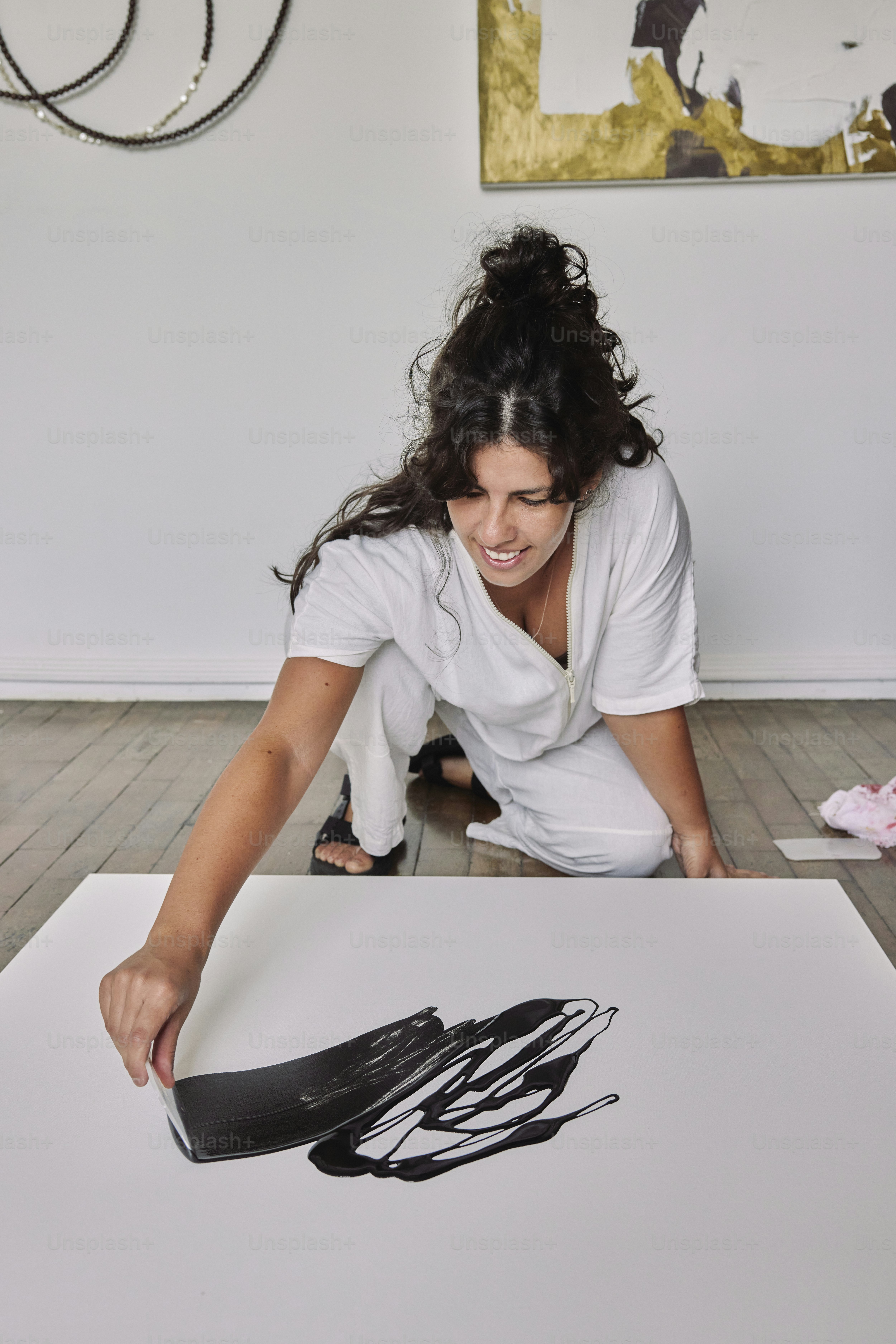 una donna seduta sul pavimento che lavora su un'opera d'arte
