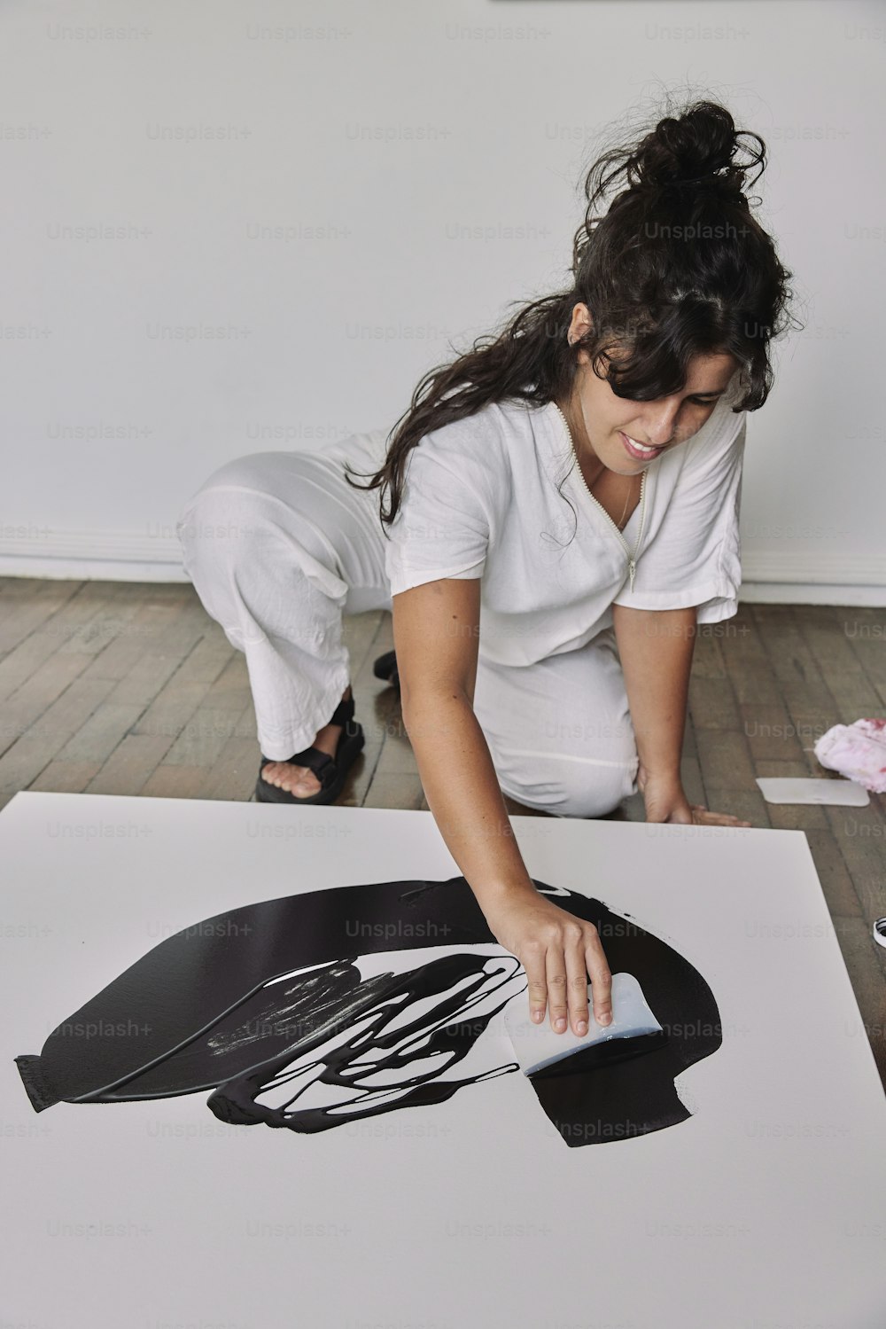 a woman in a white shirt is working on a picture