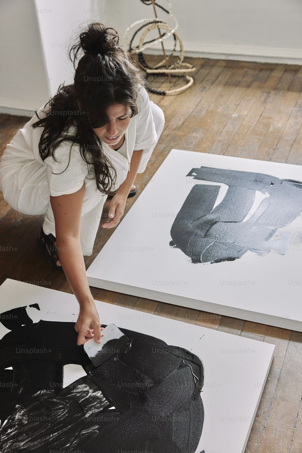 Una mujer está pintando un cuadro en el suelo