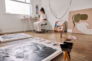 una donna seduta su una sedia di fronte a un dipinto