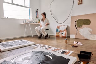 a woman sitting on a chair in an art studio