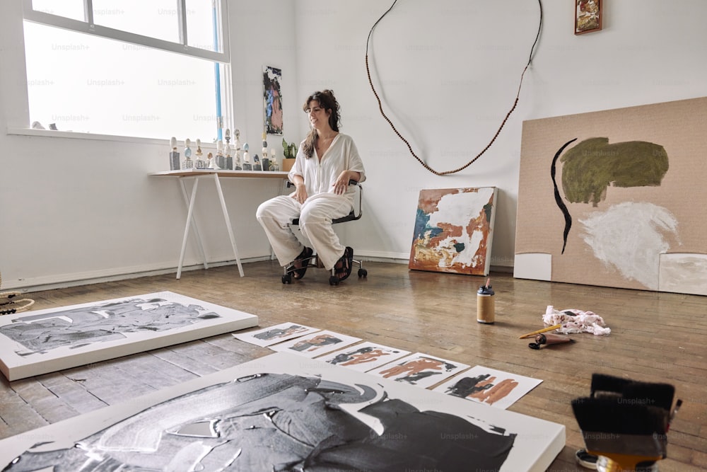 a woman sitting on a chair in an art studio