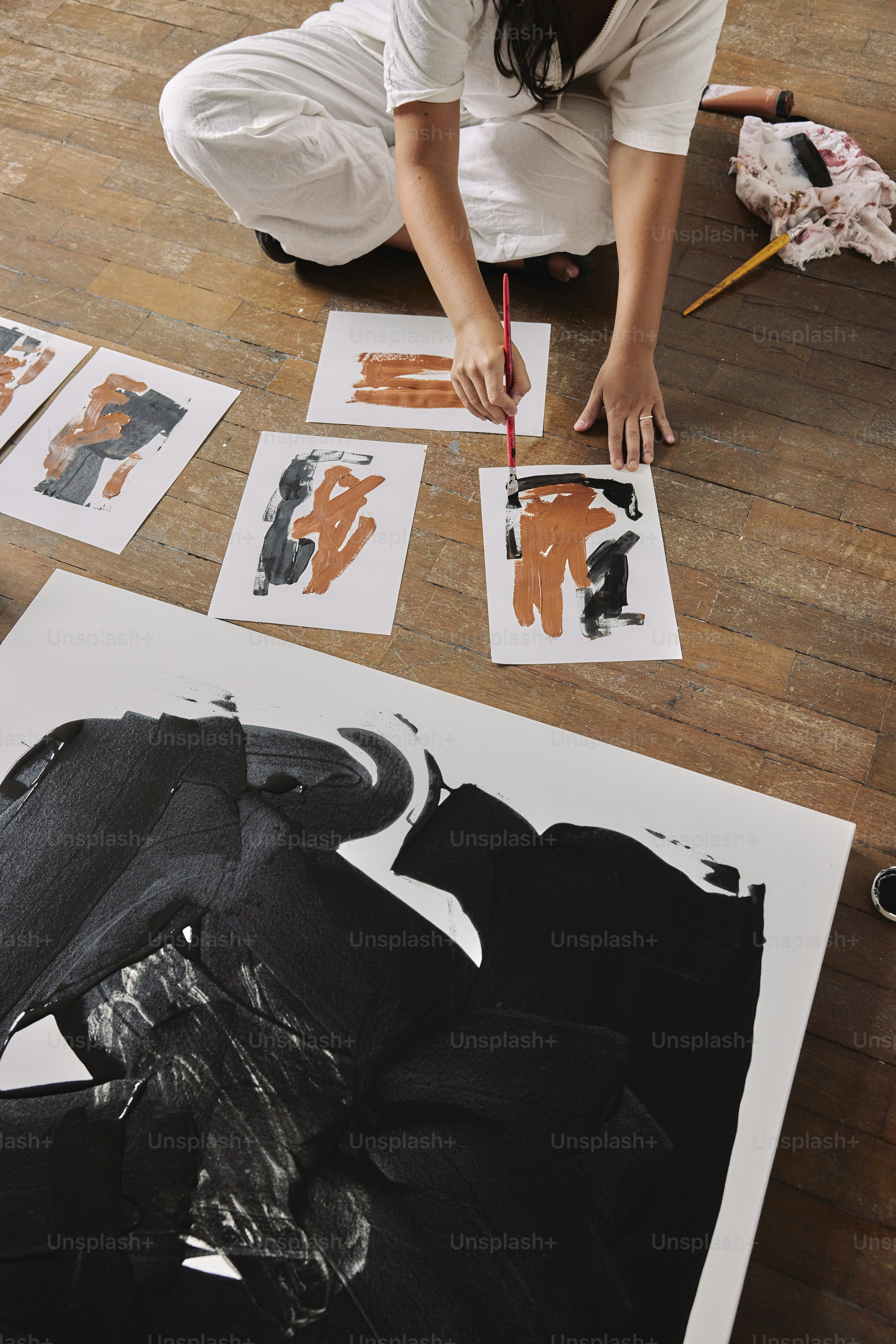 uma mulher sentada no chão trabalhando em uma pintura