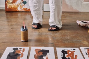 a person standing on a wooden floor next to art