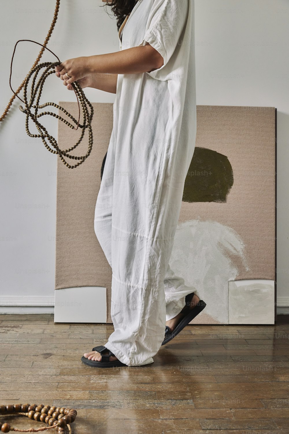 a woman standing on a wooden floor holding a rope