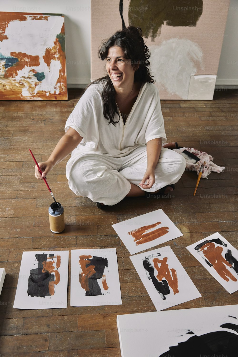 女性が床に座って絵を描いている