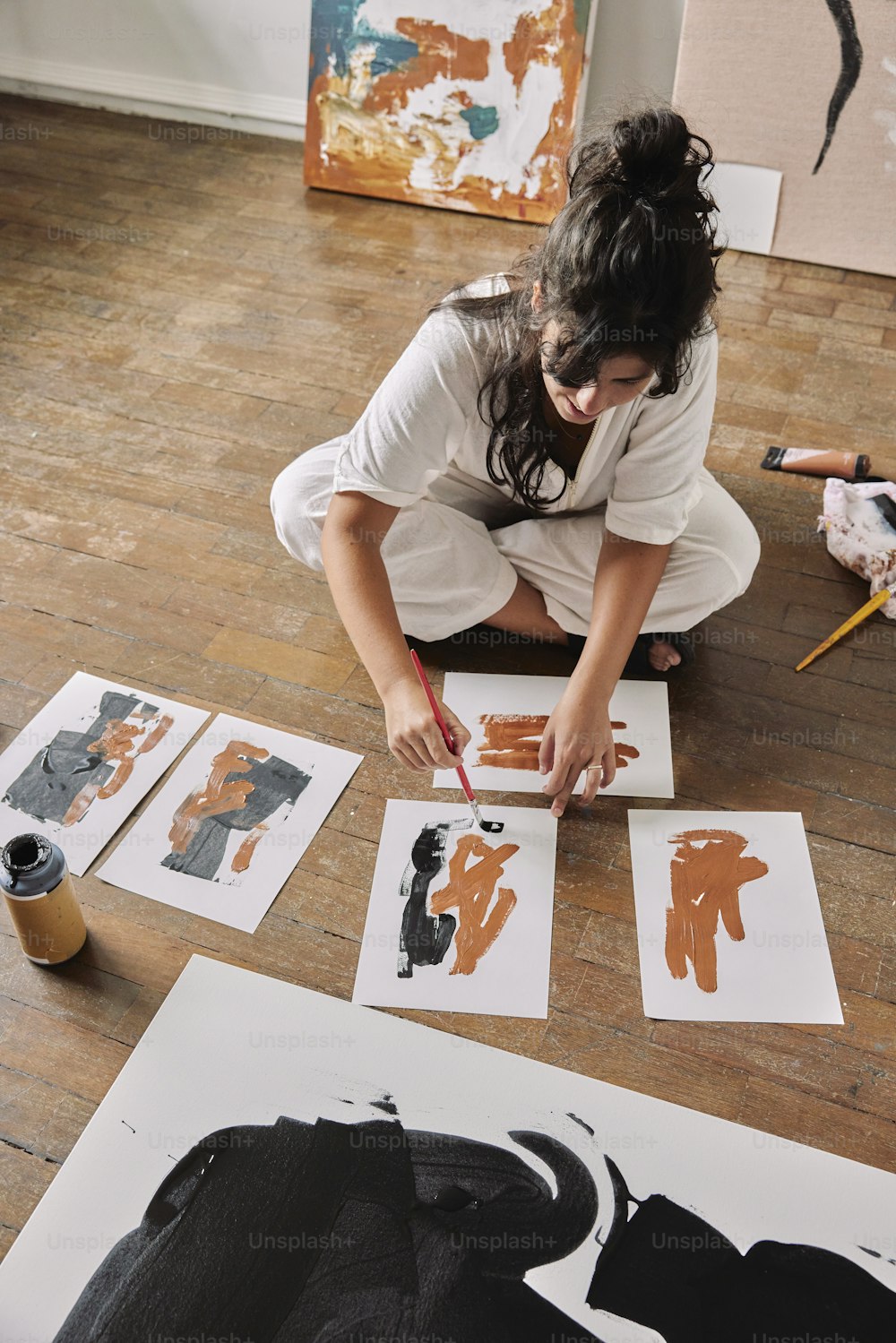 Eine Frau, die auf dem Boden sitzt und an einem Kunstwerk arbeitet