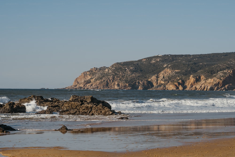 a large body of water sitting next to a rocky shore