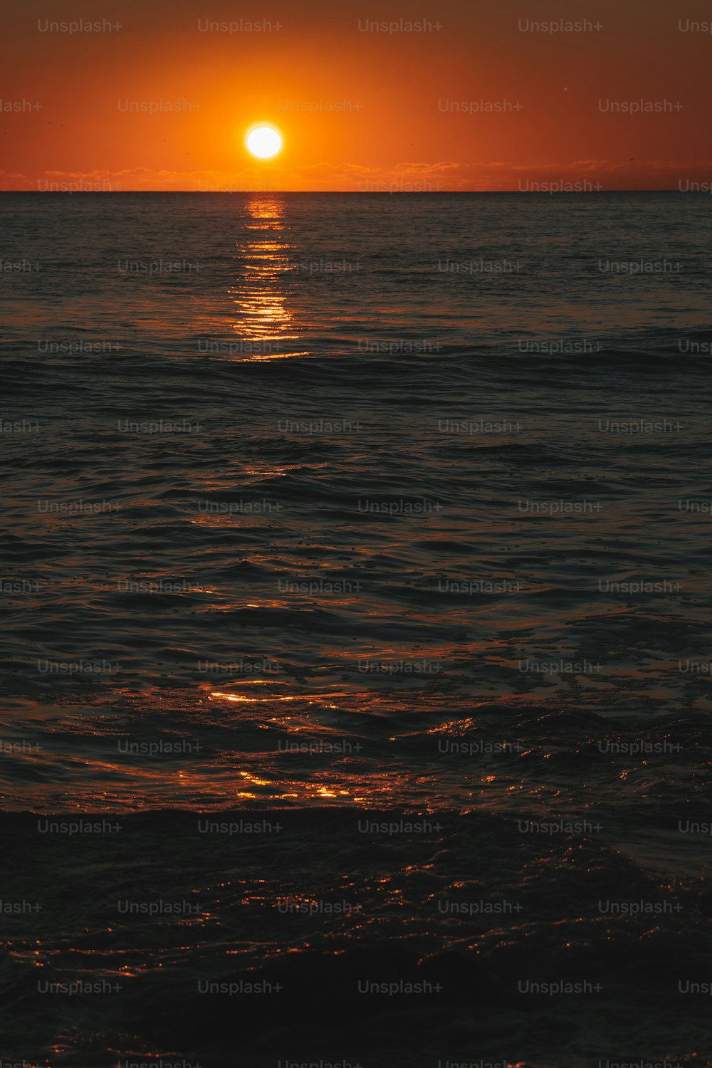 Le soleil se couche sur l’océan avec des vagues