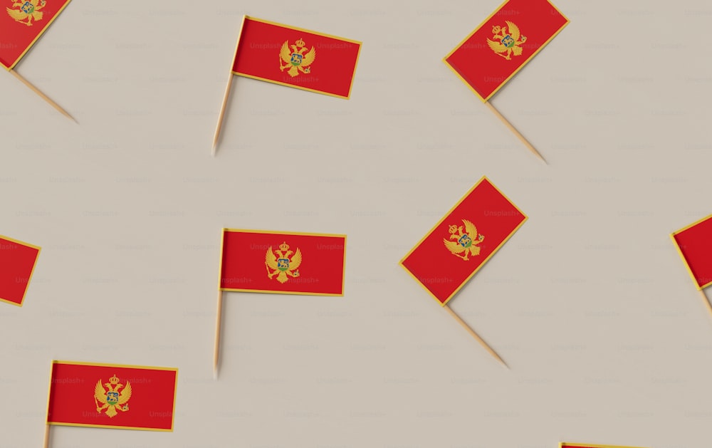 Un grupo de pequeñas banderas rojas sobre una superficie blanca