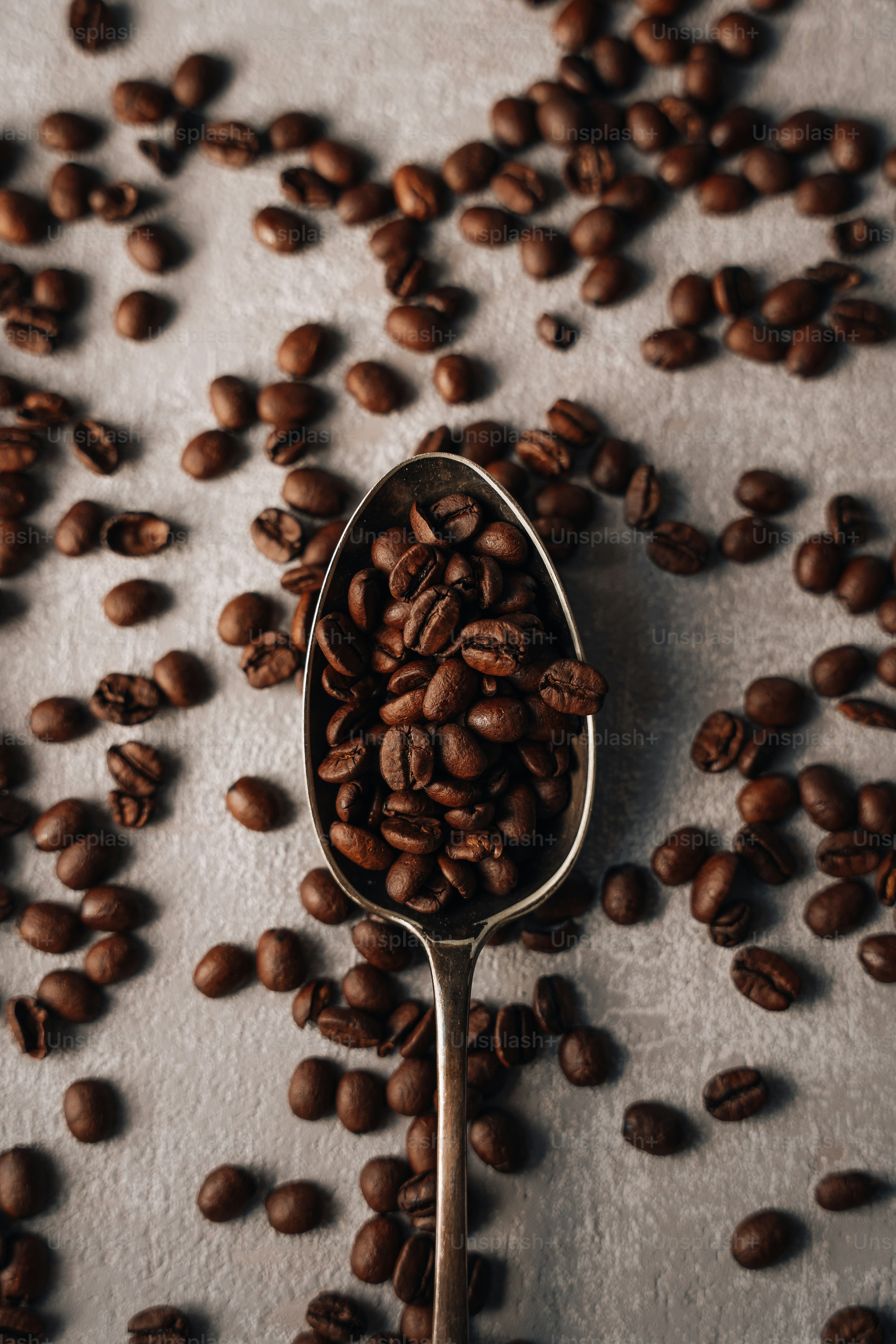 A spoon filled with coffee beans on top of a table photo – Coffee Image on  Unsplash, image size:3000x4498