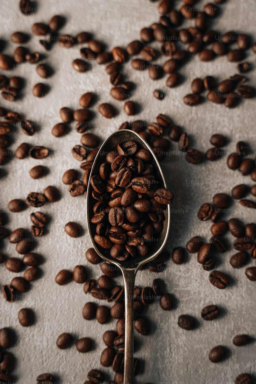 une cuillère remplie de grains de café sur une table