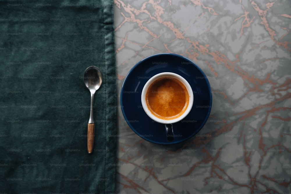 uma xícara de café e uma colher em uma mesa