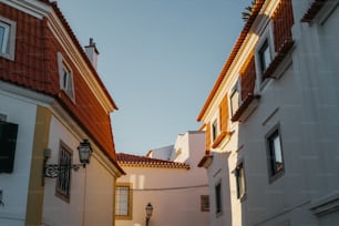 una calle estrecha con edificios blancos y una cruz en la parte superior del edificio