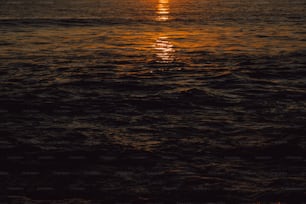 a large body of water with a sunset in the background