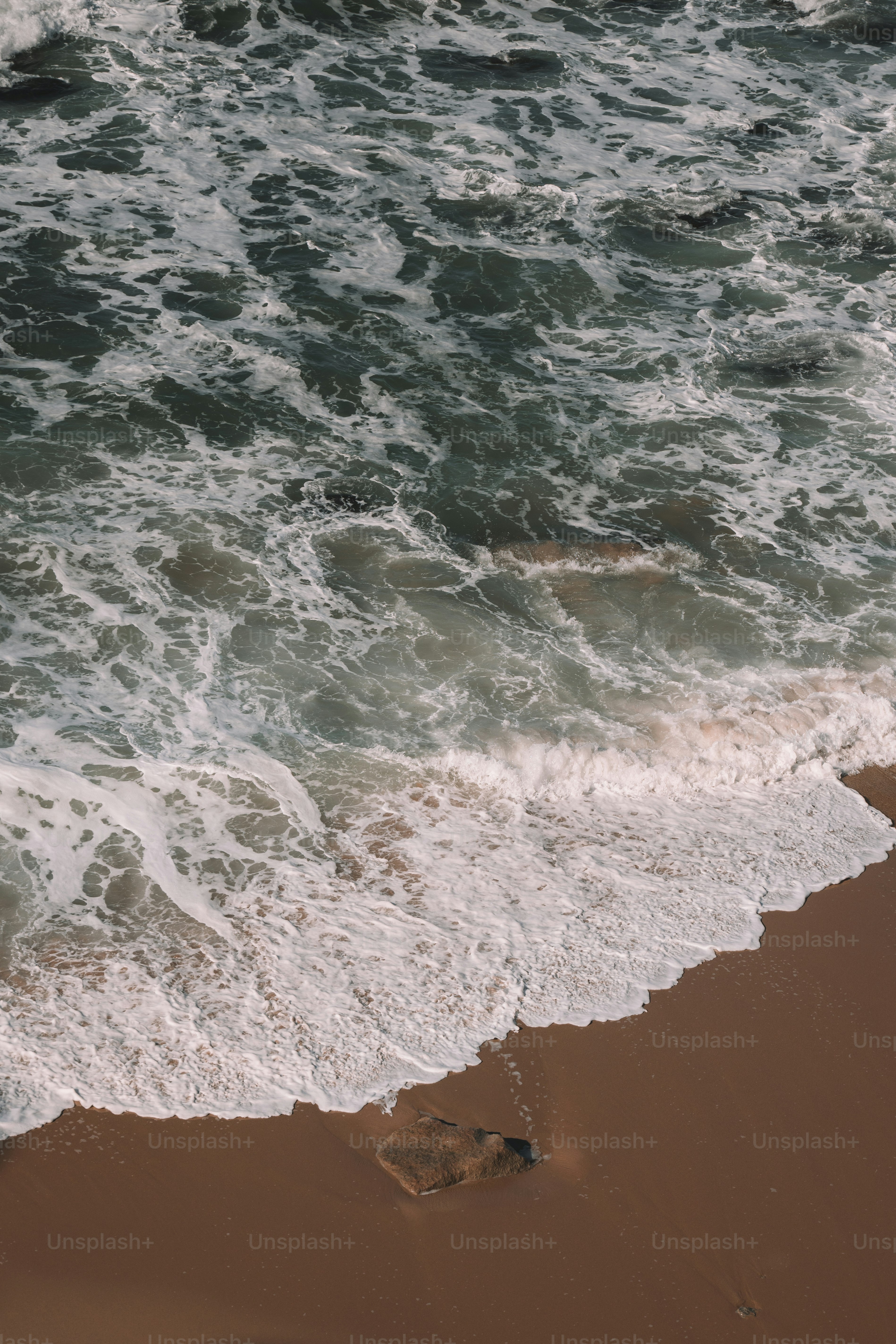 Una persona caminando por una playa junto al océano
