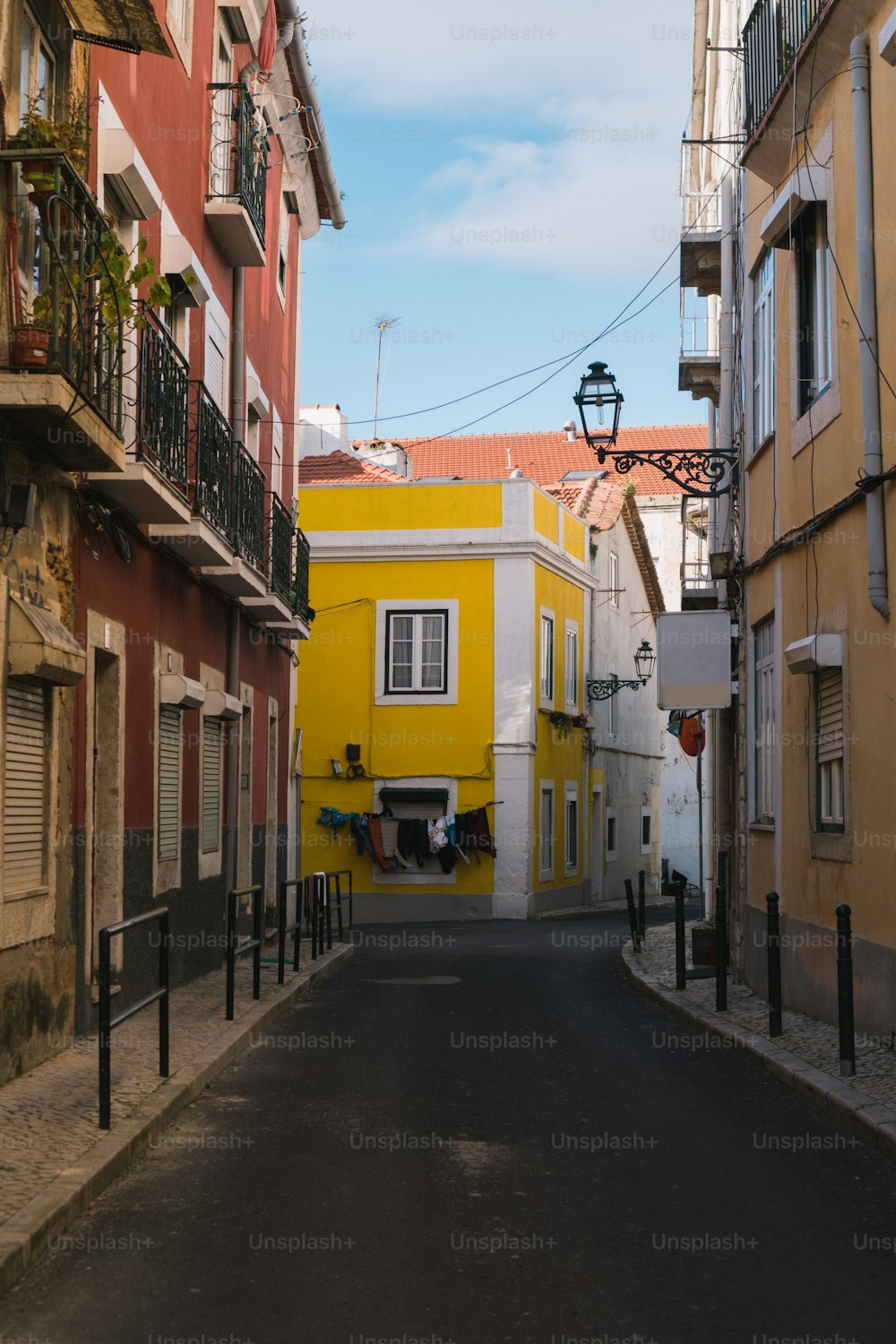 a narrow city street with a yellow building