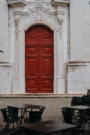 a red door sits in front of a white building
