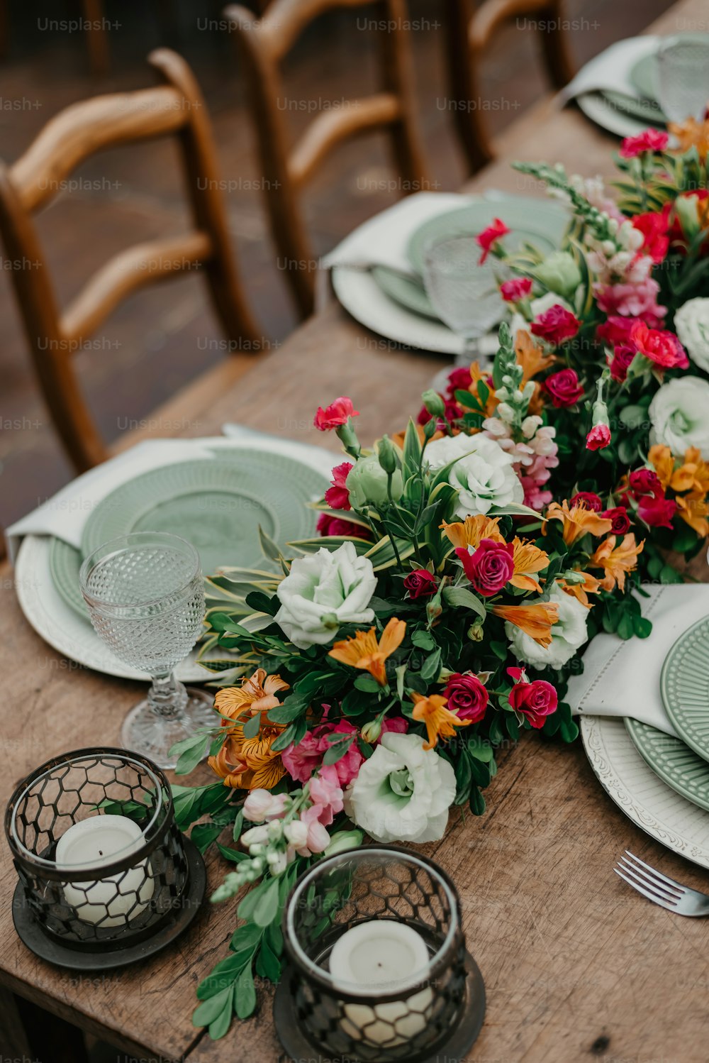 uma mesa de madeira coberta com pratos e flores