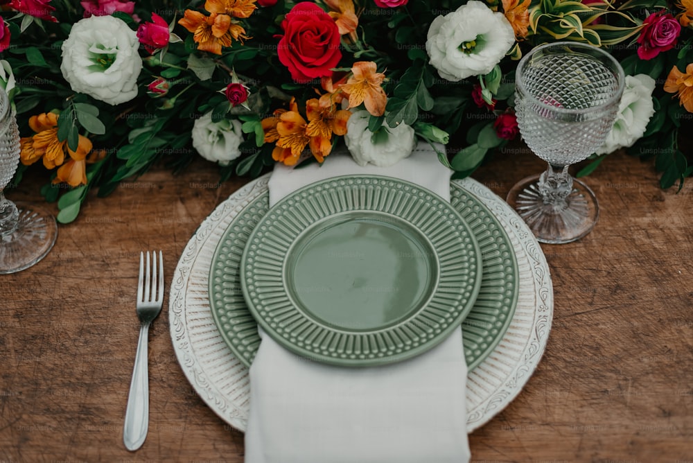 a table set with a plate, silverware, and flowers