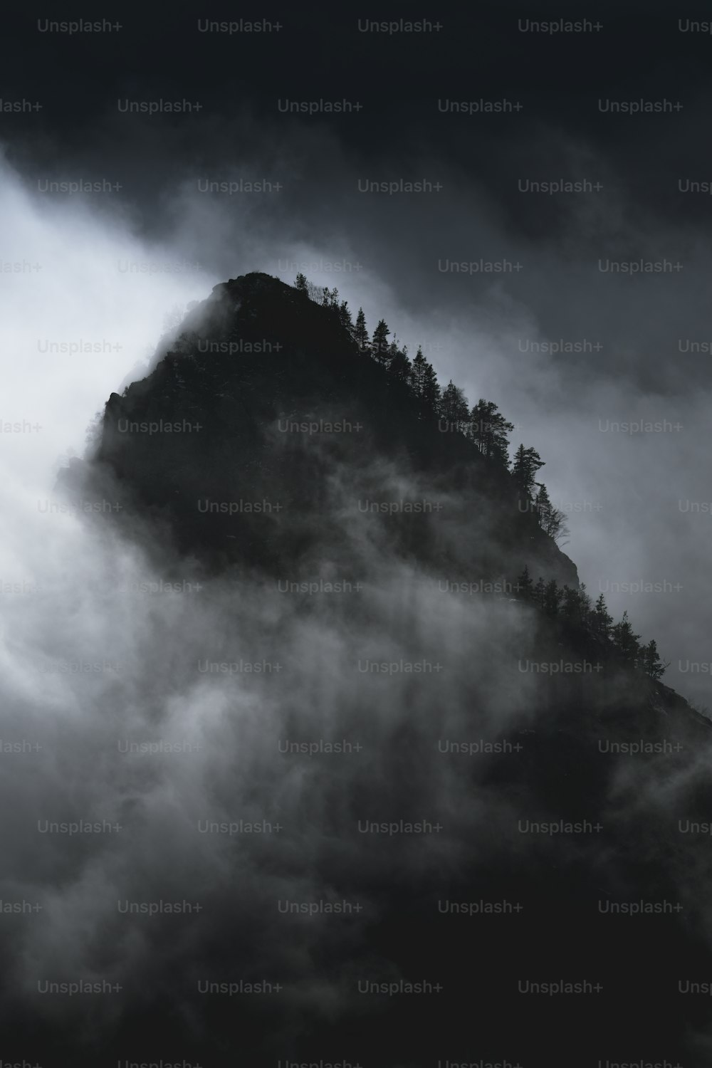 雲に覆われた山の白黒写真