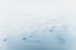 a snow covered hill with footprints in the snow