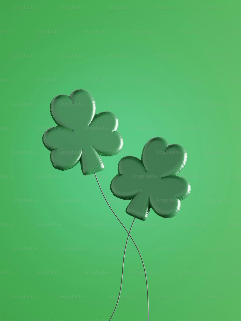 two balloons shaped like shamrocks on a green background