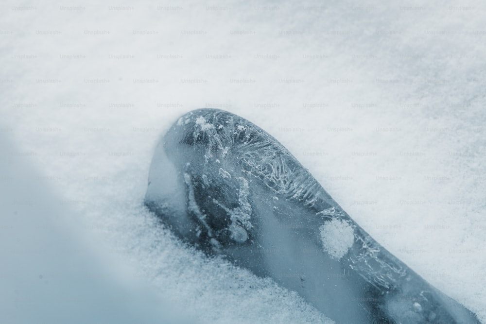 a snowboarder's foot sticking out of the snow