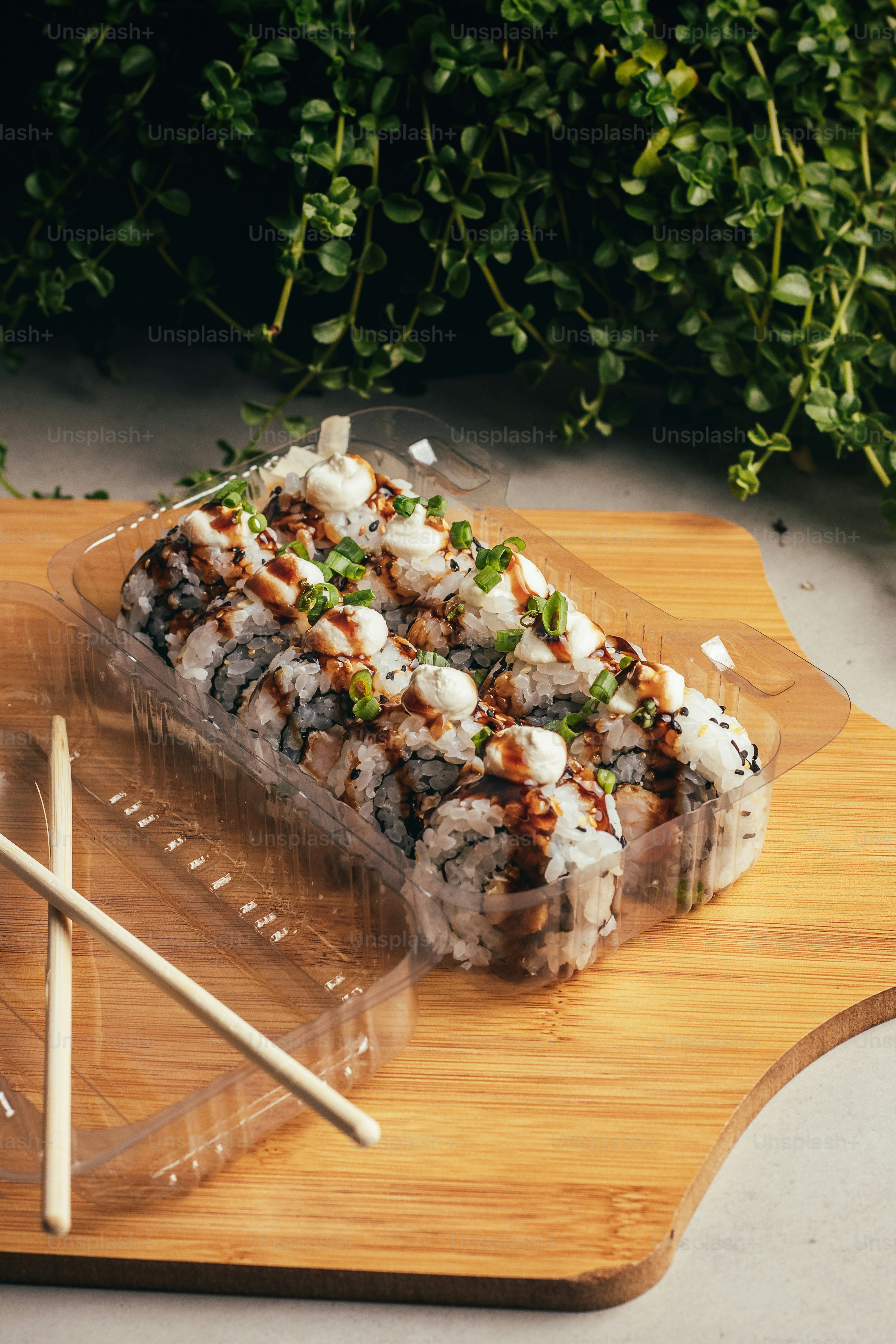 une planche à découper en bois garnie de sushis et de baguettes