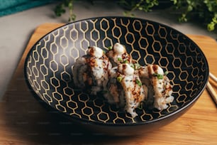 a black bowl filled with food on top of a wooden table