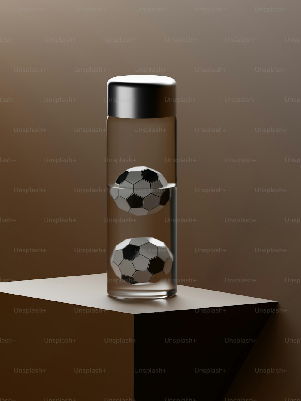 a glass container with two soccer balls in it