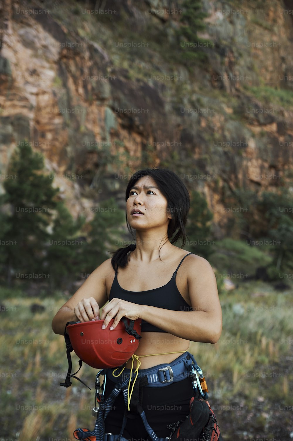 a woman in a black top holding a red helmet