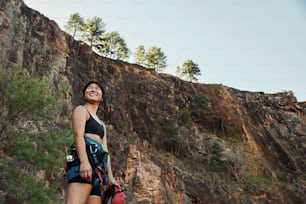 Una mujer parada frente a un acantilado