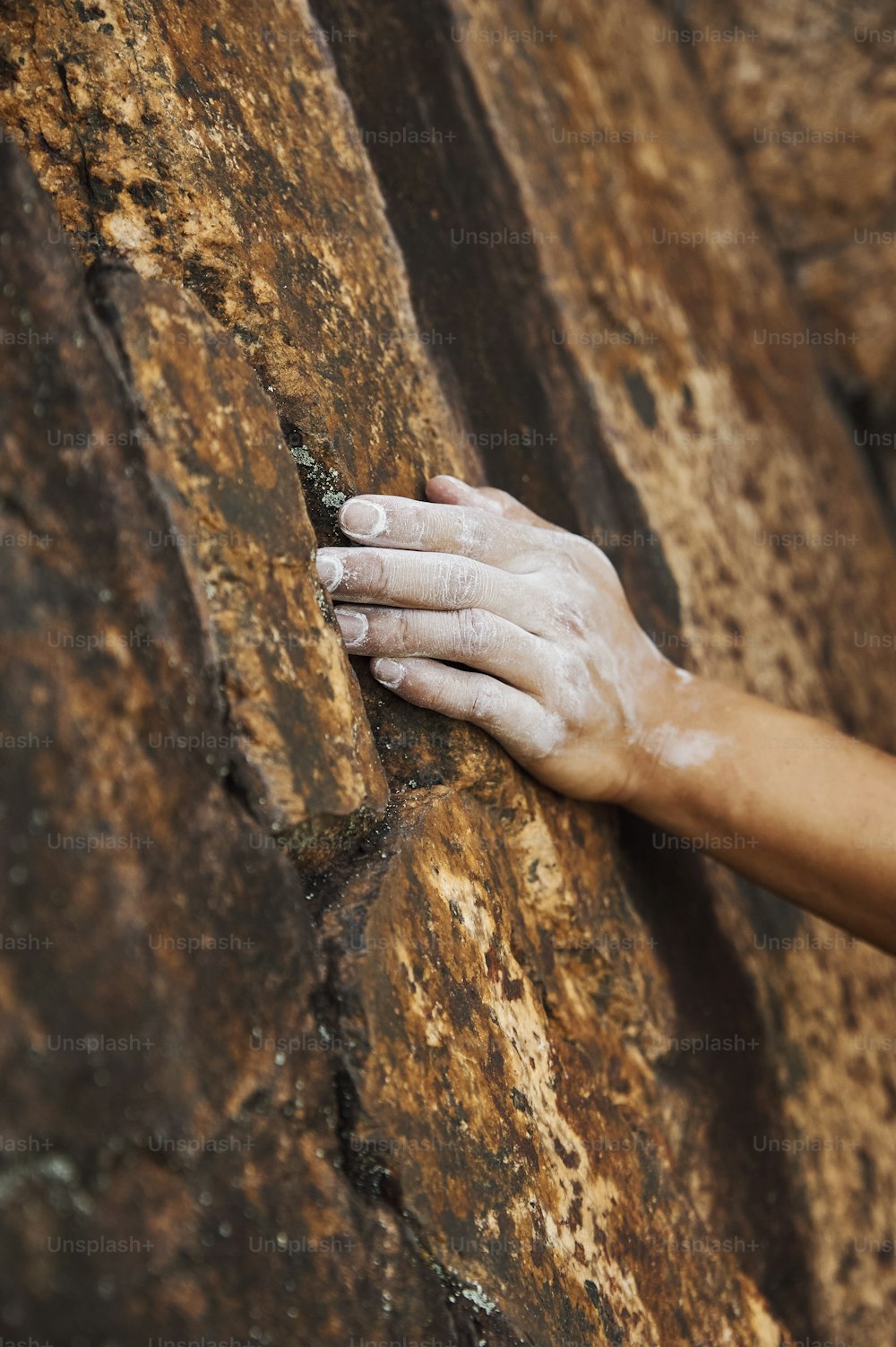a person climbing up the side of a large rock