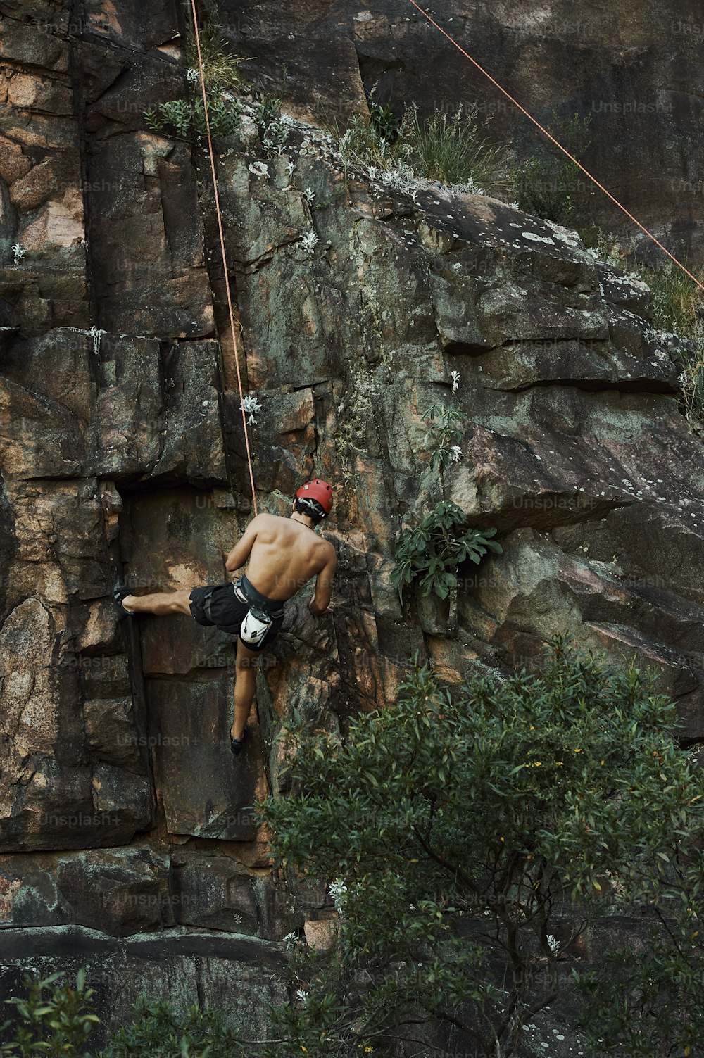 a man climbing up the side of a mountain