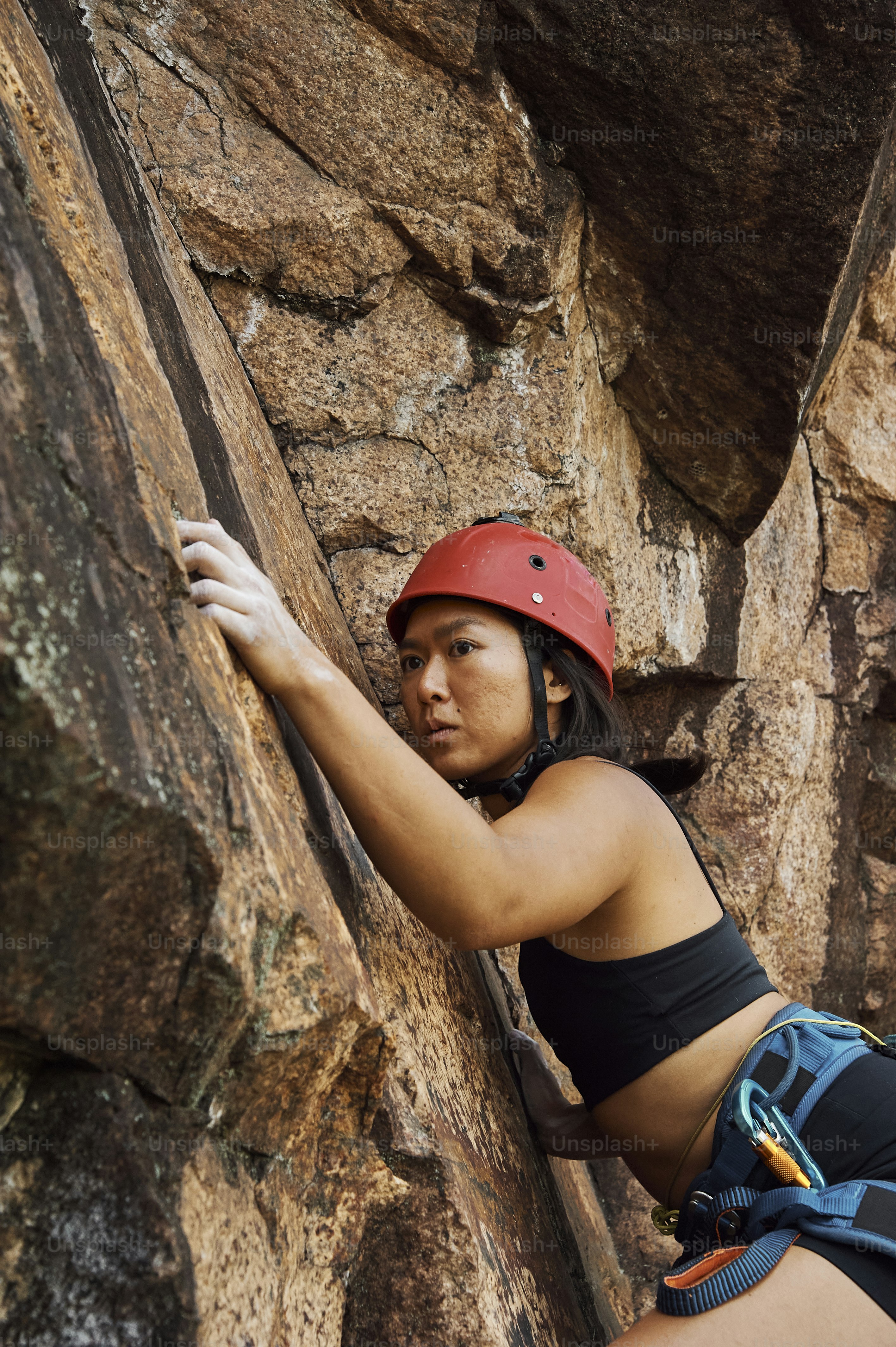 Une femme grimpe sur le flanc d’une montagne